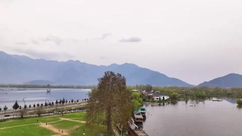 Drone pullback revealing Srinagar city, Dal Lake, and Himalayan mountains. Видео 333793149
