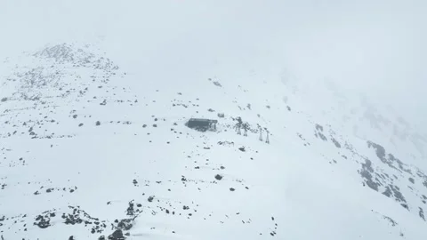 Drone pullback shot revealing snow-covered Phase 2 Gondola station in Gulmarg. Stock Footage 333801275