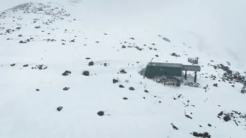 Drone pullback shot revealing snow-covered Phase 2 Gondola station in Gulmarg. Видео 333801453