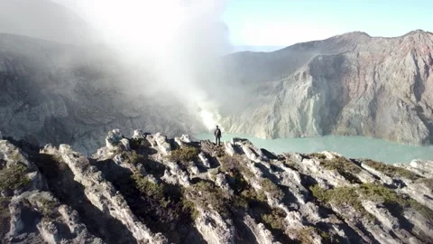 Drone Pullback of Traveler on Volcano Edge in 4K Stock Footage 315224483