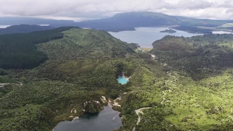 Drone pullback Waimangu Volcanic Valley lakes and forest New Zealand aerial Video stock 333829671