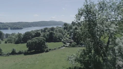 Drone Pulling away from lake, over houses, Lake District - DLog Video stock 90912458
