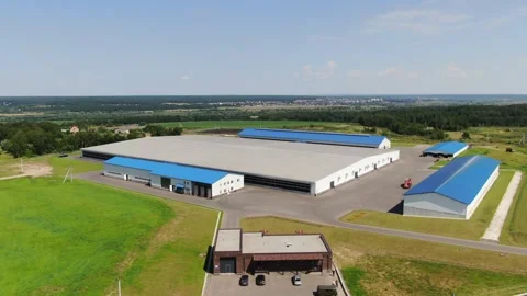 Drone pulling back above large modern farm buildings Видео 333277978