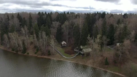 Drone pulling back above riverside forest glamping Vidéo 329742246