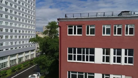 Drone pulling back and descending past hospital wing Stock Footage 328994980