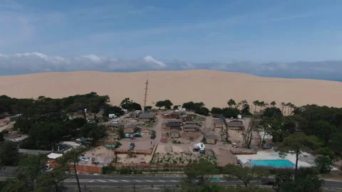 Drone pulling back from camping to wide view of forest, dune and bay, France Stock Footage 333108523