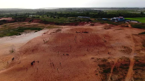 Drone pulling back from distant dirt football field, Senegal Stock Footage 331991920
