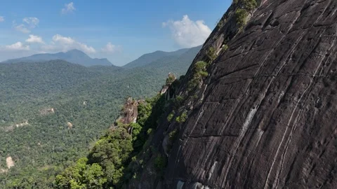 Drone pulling back from giant rock revealing layered mountain landscape 스톡 동영상 336956336
