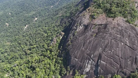 Drone pulling back from giant rock revealing layered mountains behind 動画素材 336956501
