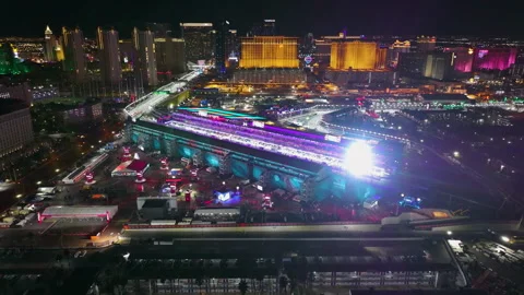 Drone pulling back from the illuminated Pit lane, Grand prix in night Las Vegas Stock Footage 306276899