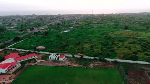 Drone pulling back over plain to reveal stadium, Youssoupha Ndiaye, Senegal Stockbeeldmateriaal 331989574