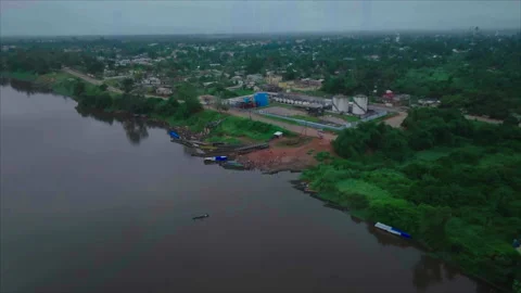 Drone pulling back from people at riverbank to overall view, Ouesso, Congo Stock Footage 331999796
