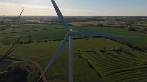 Drone pulling back from wind turbine over green countryside landscape Stock-Footage 333935397