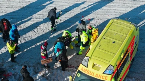 Drone Pulls Away As Paramedics Rescue Injured Racer During Moto Skijoring Event Video stock 346858629
