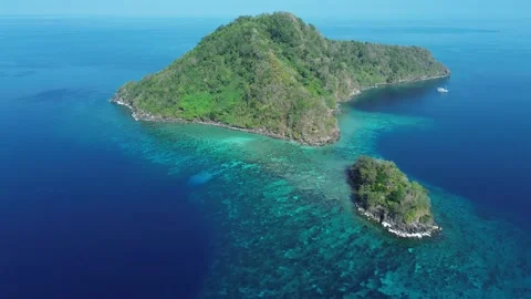 Drone pulls back above reef showing boat and coast Video stock 327465978