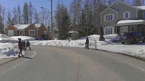Drone Pulls Back from Four Kids Playing Hockey in Snow Covered Streets of Video stock 139762290