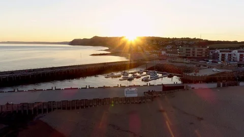 Drone pulls back from harbor and town of West Bay in Dorset Stock Footage 94365504