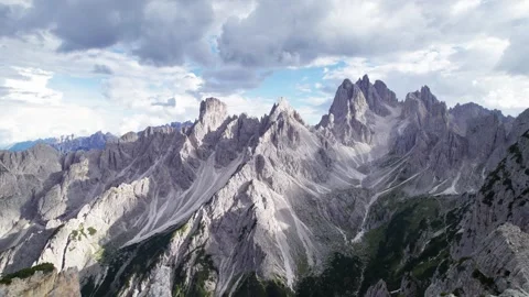 Drone pulls back from a hiker facing the Cadini di Misurina peaks Stock Footage 346287933