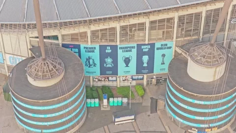 Drone push-in descent toward Etihad Stadium main entrance and trophy façade Stockbeeldmateriaal 341902759