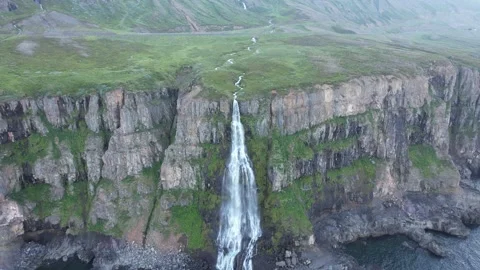 Drone push in to Migandi waterfall on basalt sea cliff, North Iceland Stock Footage 346552179