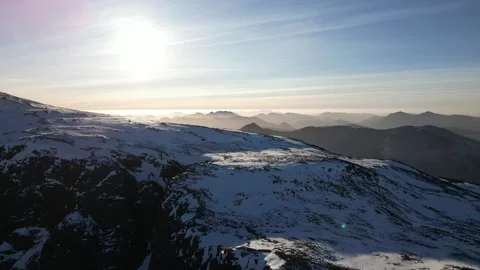 Drone push over Ben Nevis North Face crags revealing snowy plateau Stock Footage 330577086
