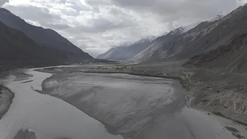 Drone Push In Over Dry Ladakh River Landscape with Snow Covered Distant Peaks Stock Footage 335762870