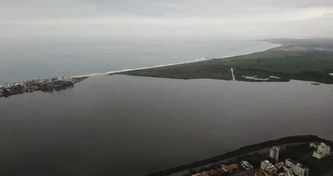 Drone push-in shot of Macaé cityscape with ocean and Imboassica Lagoon Stock Footage 317731129