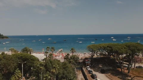 Drone push-in shot of summer beach in Saint-Tropez with umbrellas, turquoise sea Stock Footage 306296470
