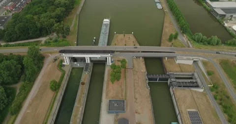 Drone Push-In Toward Opening Dutch Sluice Gate for Cargo Ship with Road Above Stock Footage 342346832