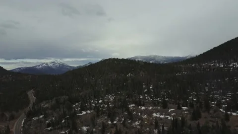 Drone push in toward trees and snowy mountains Video stock 167675207