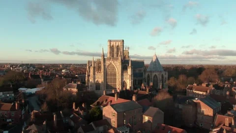 Drone push in towards historic York cathedral on glowing sunrise morning Stock Footage 168069600