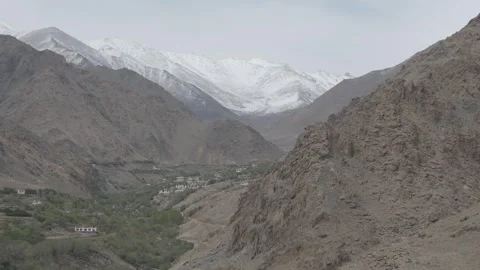 Drone Push In Towards Snow Capped Ladakh Peaks with Valley Village Houses Over Stock Footage 335760634