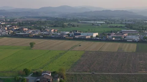 Drone push in tracking freight train across Po Valley near Fiorenzuola with Stock Footage 334706369