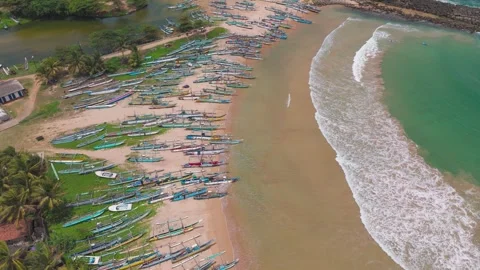 Drone Push-In View of Colorful Outrigger Boats Resting in a Tropical Bay Shore Stock Footage 319918191