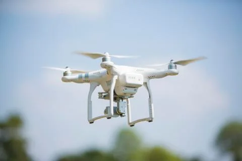 Drone quad copter with high resolution digital camera flying hovering in the  Stock Photos