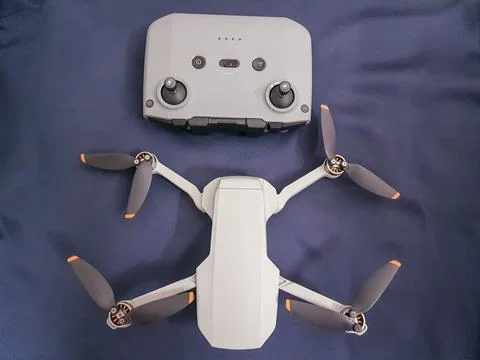 Drone quad copter with its remote and dark blue background from different ang 스톡 사진