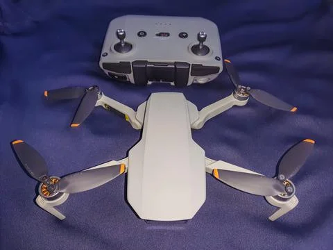 Drone quad copter with its remote and dark blue background from different ang Stock-Fotos