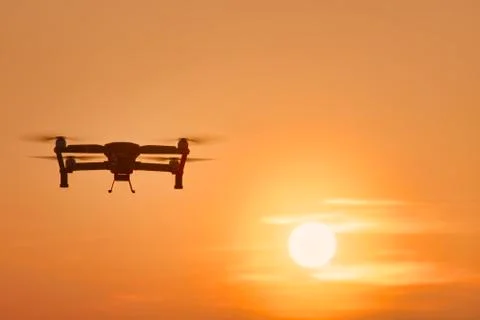 Drone quad copters with high resolution digital camera flying aerial over sun Foto stock