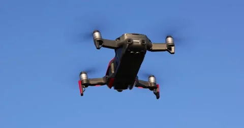 Drone quadcopter with digital camera and fast rotating propellers flying Video stock 259970479