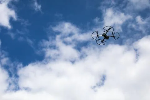 Drone quadcopter with digital camera on blue sky background 库存照片