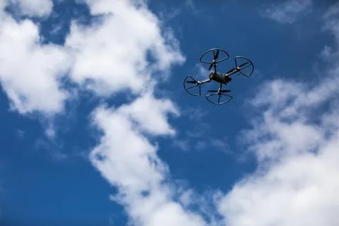 Drone quadcopter with digital camera on blue sky background Stock Photos