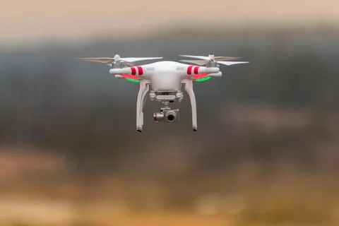 Drone quadcopter with digital camera flying at sunset Stock Photos