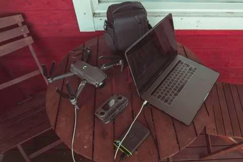 Drone quadcopter with a flight controller and notebook on the old wooden table. Stock Photos