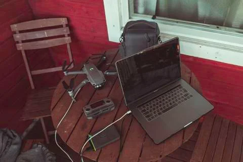 Drone quadcopter with a flight controller and notebook on the old wooden table. Stock-Fotos