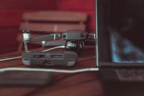 Drone quadcopter with a flight controller and notebook on the old wooden table. Stock-Fotos