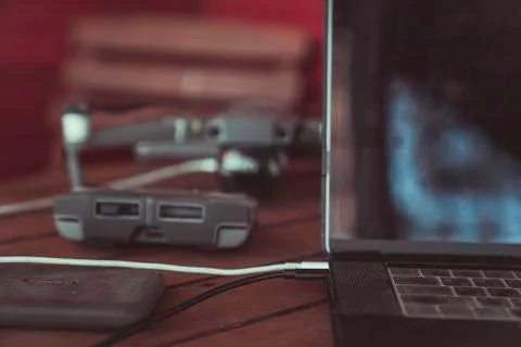Drone quadcopter with a flight controller and notebook on the old wooden table. Stock Photos