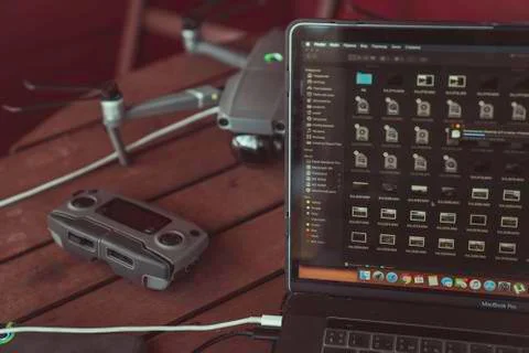 Drone quadcopter with a flight controller and notebook on the old wooden table. Stock-Fotos