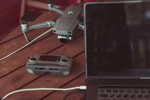 Drone quadcopter with a flight controller and notebook on the old wooden table. Stock-Fotos