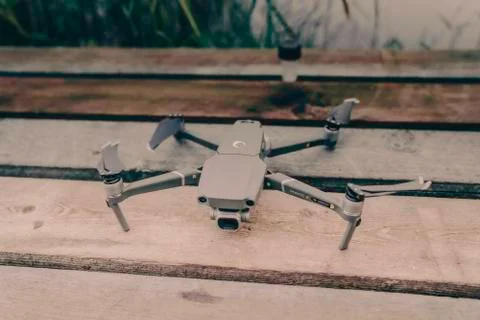Drone quadcopter with a flight controller and notebook on the old wooden table. Stock Photos