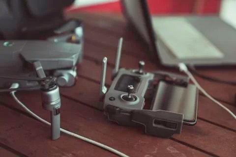 Drone quadcopter with a flight controller and notebook on the old wooden table. Stock Photos